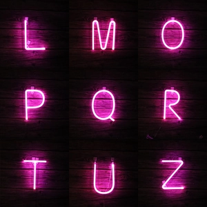 Pink LED neon alphabet letters L to Z on dark wood wall for festive decoration