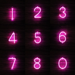 Pink LED neon number lights for festive party decoration on dark wooden background