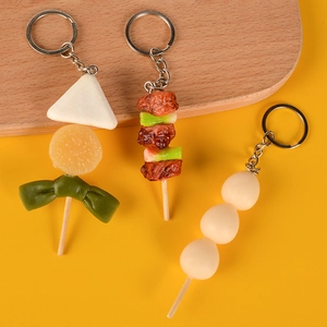 Realistic food skewer keychains with barbecue and egg models on a bright background
