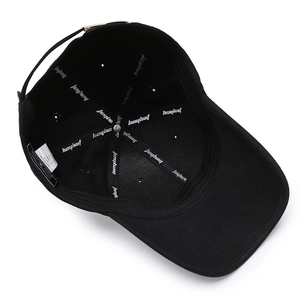 Inside view of black cotton baseball cap showing interior lining and adjustable metal buckle
