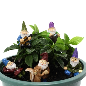 Ensemble miniature de jardin avec nains en résine et écureuil dans le terreau d'un pot