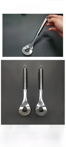 Macro view of stainless steel meatball maker with drip-shaped hole and long handle