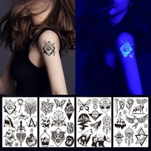 Detail of neon heart and wolf temporary tattoo set showing day and UV glow effects