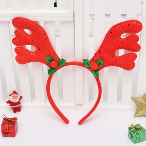 Detail of red Christmas reindeer antler headband with sequins and holly berries decor
