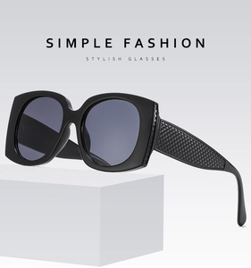 Macro detail of black square oversized sunglasses with diamond-patterned texture temples