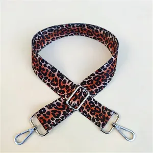 Detailed view of leopard print bag strap featuring silver metal swivel hooks and buckles