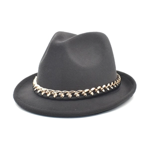 Close-up of black fedora hat with gold metal chain band decoration and wool finish