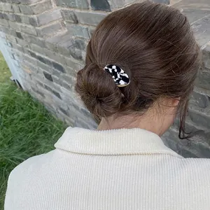 French style hair claw clip with black and white marble pattern and gold metal edges