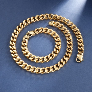 Détail de l'ensemble collier et bracelet à mailles gourmettes dorées sur fond bleu texturé