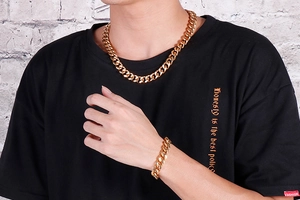 Gros plan d'un ensemble collier et bracelet maille gourmette dorée épaisse pour homme