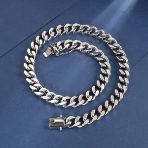Detail of silver Cuban link chain with secure plug-in clasp on dark blue background