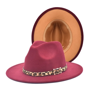 Détail du fedora bordeaux avec bande léopard et boucle dorée montrant le bord bicolore chameau