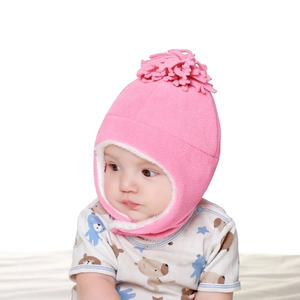 Close-up of pink fleece toddler earflap hat with decorative tassel on top