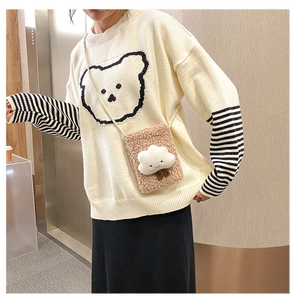 Detail of cute lamb wool cloud crossbody bag paired with a striped knit sweater