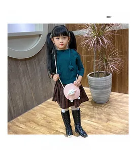Detail of pink sheep plush crossbody bag styled with autumn girl outfit in home setting