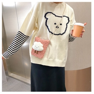 Detailed texture of pink faux shearling phone bag with 3D cloud doll on model