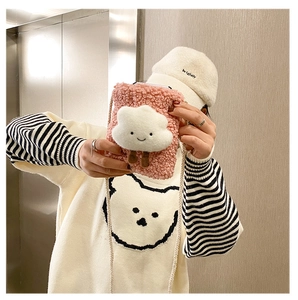 Detailed view of pink lamb wool crossbody bag with 3D cloud smiley face decoration