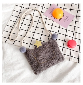Detailed macro of grey plush crown kids bag with golden star and furry pompom accents