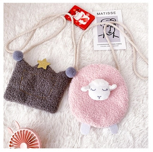Pink lamb and grey crown plush crossbody bags for kids on a soft white faux fur rug