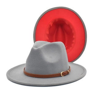 Detail of gray wool fedora with red contrast brim and brown leather band with gold buckle