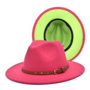 Detail of rose red fedora hat with neon green lining and brown leather buckle strap