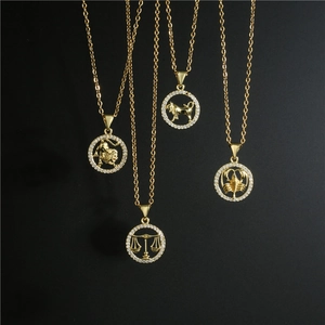 Gold 12 zodiac pendant necklace with micro-pave crystals on dark background