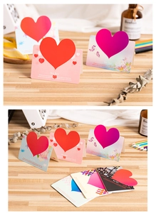Detail of 3D heart greeting cards with romantic text standing on a wooden surface