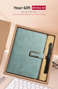 Close-up of leather A5 notebook with metal buckle and pen in premium gift set