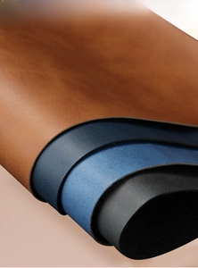 Macro detail of textured imitation leather in brown, blue, and black for business notebooks