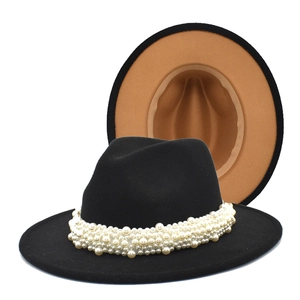 Detail of elegant pearl bead embellishment on black wool fedora hat with wide brim