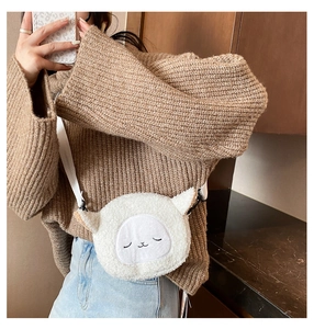 Detail view of a white plush cartoon shoulder bag with cute embroidery and 3D ears