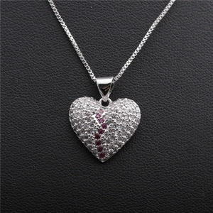 Silver broken heart pendant necklace with red and clear crystals on black leather base