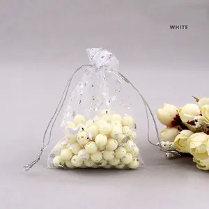 Detailed shot of white organza jewelry bags with silver foil stars and moon patterns