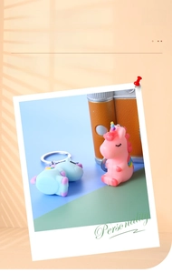 Detail of cute PVC cartoon unicorn keychains in pink and blue with rainbow details