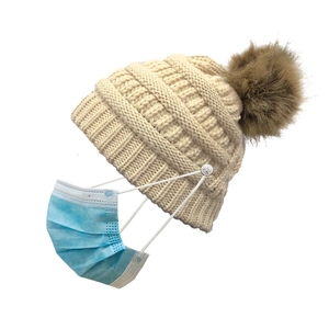 Beige knitted beanie with brown fur pom pom and buttons for face mask attachment