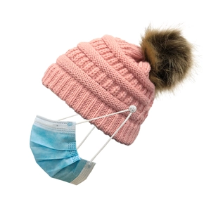 Pink knit beanie with faux fur pompom and buttons for attaching a face mask securely