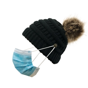 Women's black knit beanie with brown faux fur pom pom and buttons for face mask
