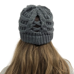 Detail view of the back ponytail hole design and crisscross knit on dark grey beanie