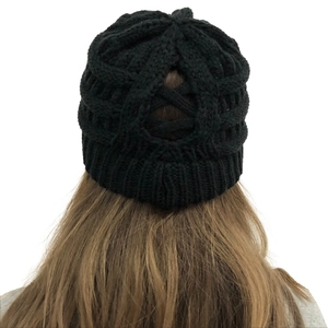 Detail showing back ponytail opening on a black chunky cable knit beanie for women