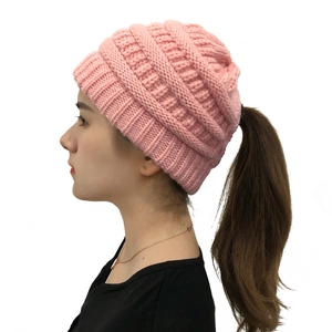 Detail view of pink knitted beanie with ponytail hole design for long hair women