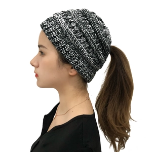 Detail showing the thick knit texture and grey-black mixed wool of the ponytail beanie