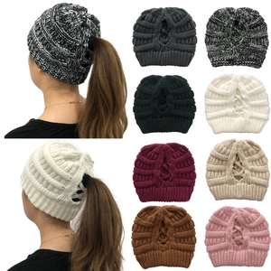 Detailed view of women's knitted ponytail beanies in eight solid colors and a crossover design