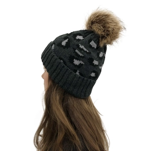 Detail of knitted leopard print beanie with soft brown faux fur pom pom and rolled edge