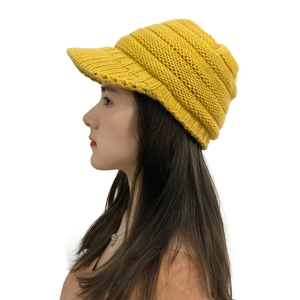 Detail of a bright yellow chunky knit beanie for women with a warm protective sun visor