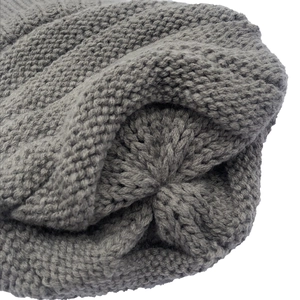 Macro shot of dark grey knit texture and top stitching detail of a winter ski beanie hat