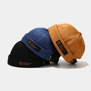 Trio of retro cotton miki hats in black, royal blue, and yellow with woven side labels