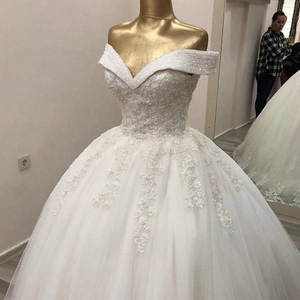 Robe de mariée blanche à épaules dénudées avec dentelle perlée et jupe volumineuse en tulle