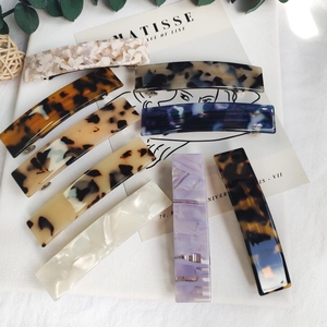 Flat lay of rectangular acetate leopard and marble hair clips with spring metal closure