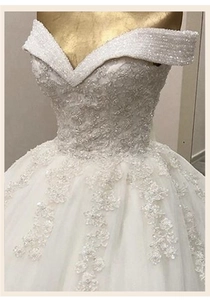 Détail d'une robe de mariée à col en V avec broderie de dentelle fine et paillettes