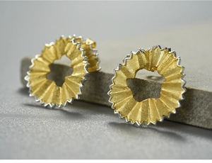 Macro shot of pencil shaving style S925 sterling silver stud earrings in gold and silver